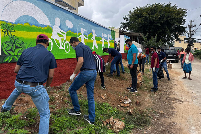 moog employee pulling weeds from ground