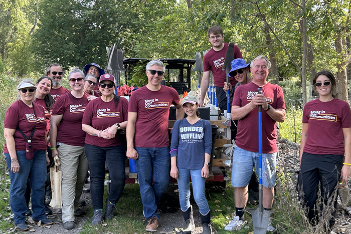 moog employee pulling weeds from ground