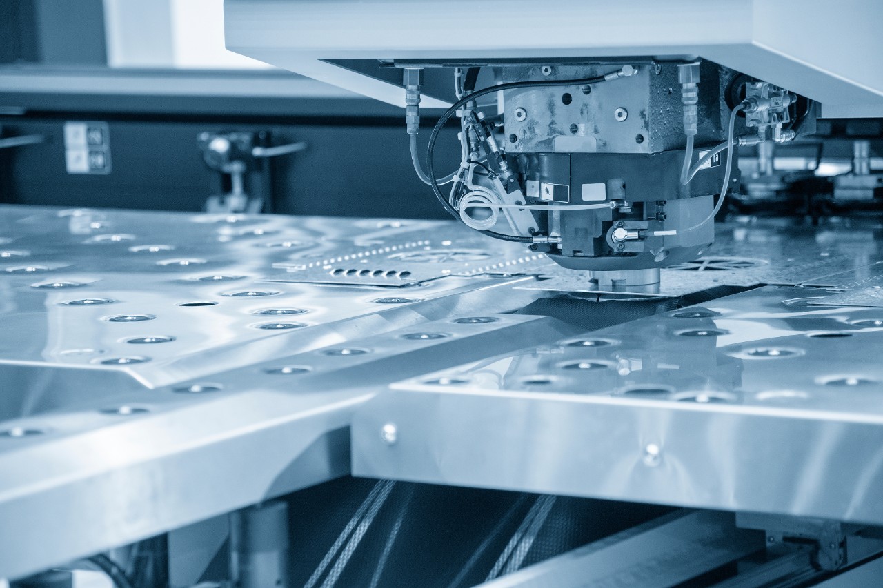 Turret punching machine cutting the metal plate. Metal forming machine.